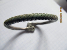 Древнерусский серебряный псевдовитой браслет с фигурными расширениями на кончиках, украшенными чернью.