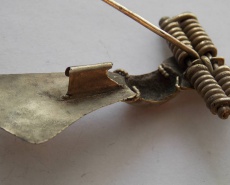 Рскрытая фибула, вид на пружину, иглу и иглоприёмник